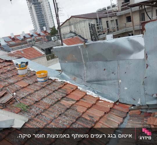 דלי צבע וכלי עבודה על גג רעפים לאיטום